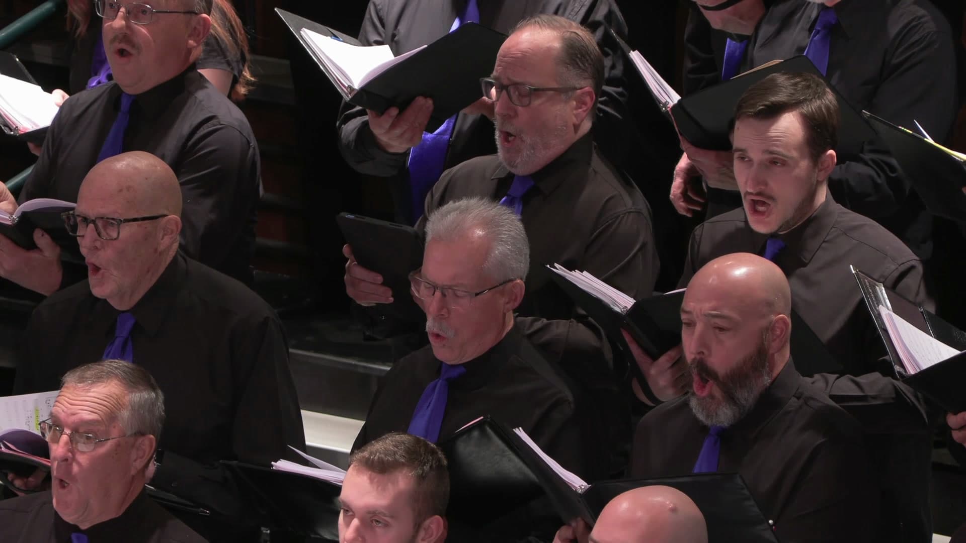 Close view of South Shore Chorale singers performing in black with purple ties